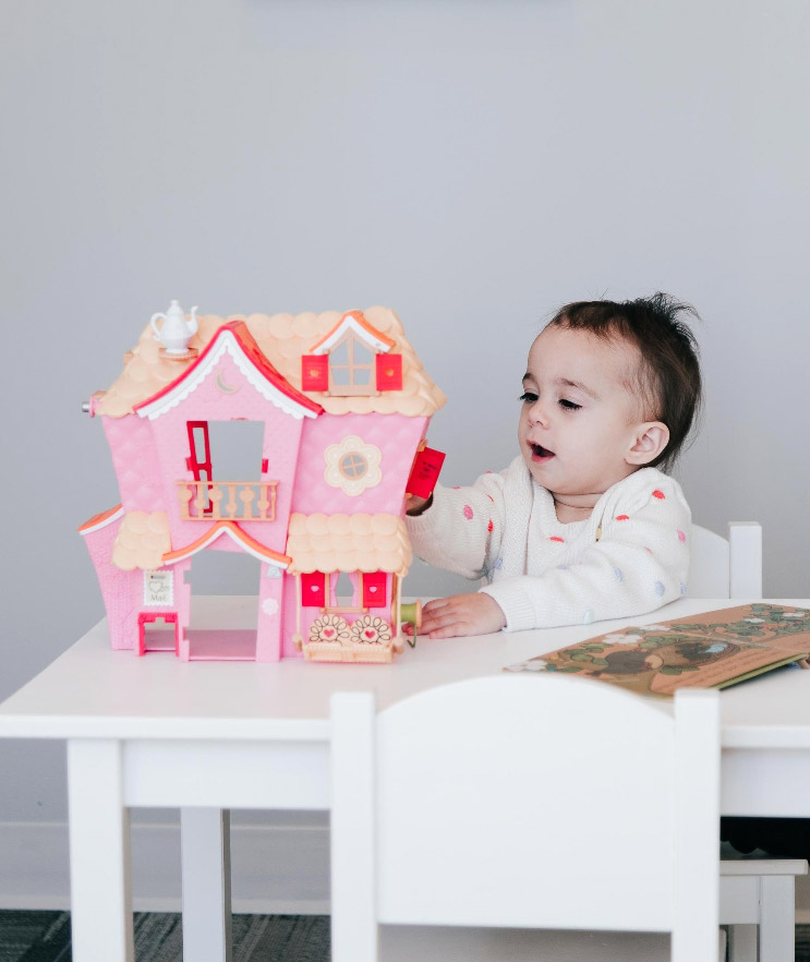 Child playing with a dollhouse